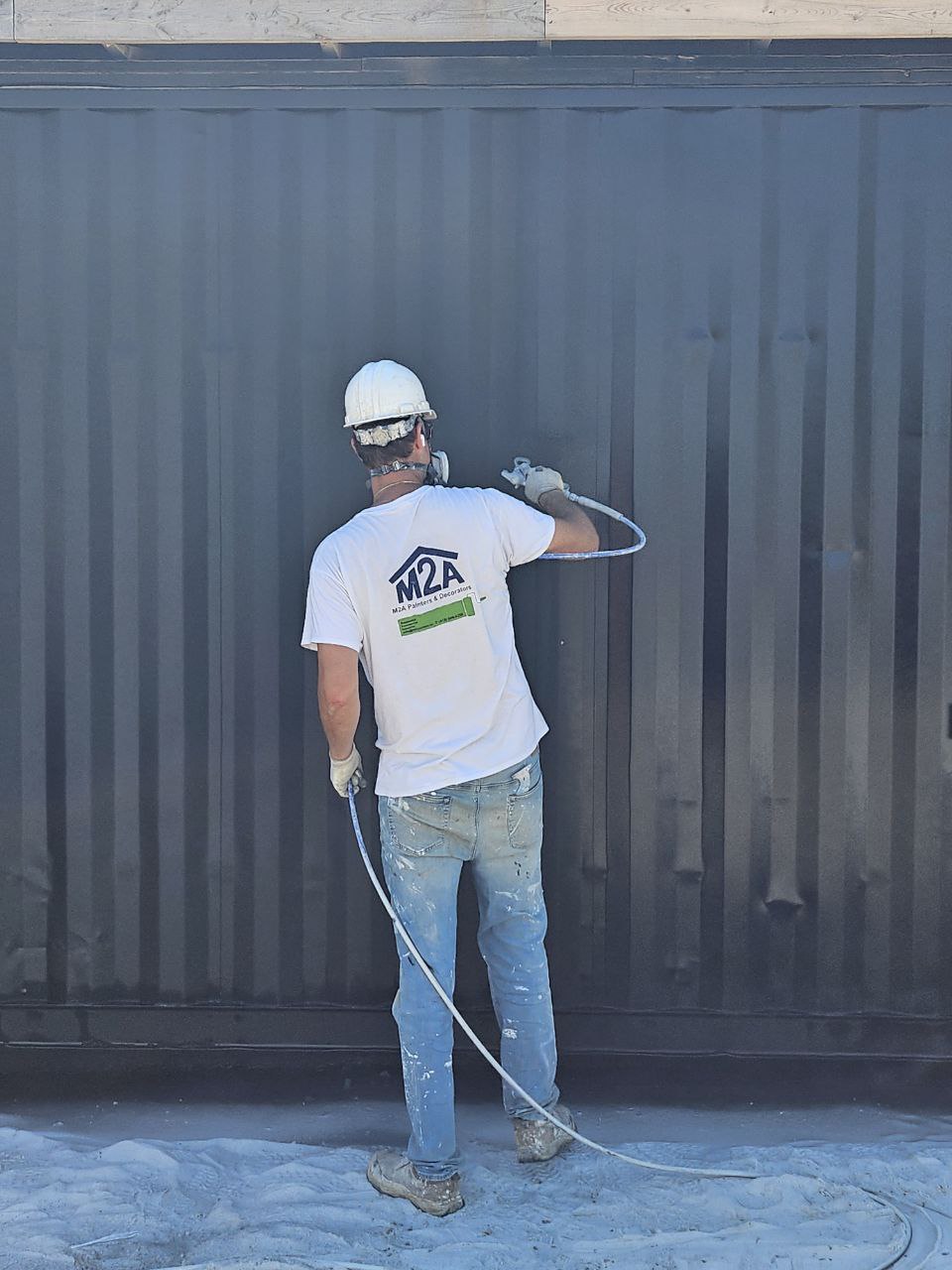 Professional painter applying paint with a roller on a residential project in Hamilton, Oakville and Burlington